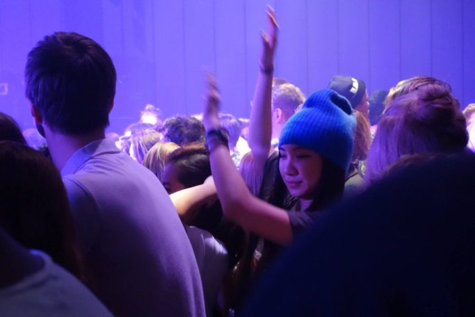 Junge Frau tanzt wie in Trance auf einem Konzert
